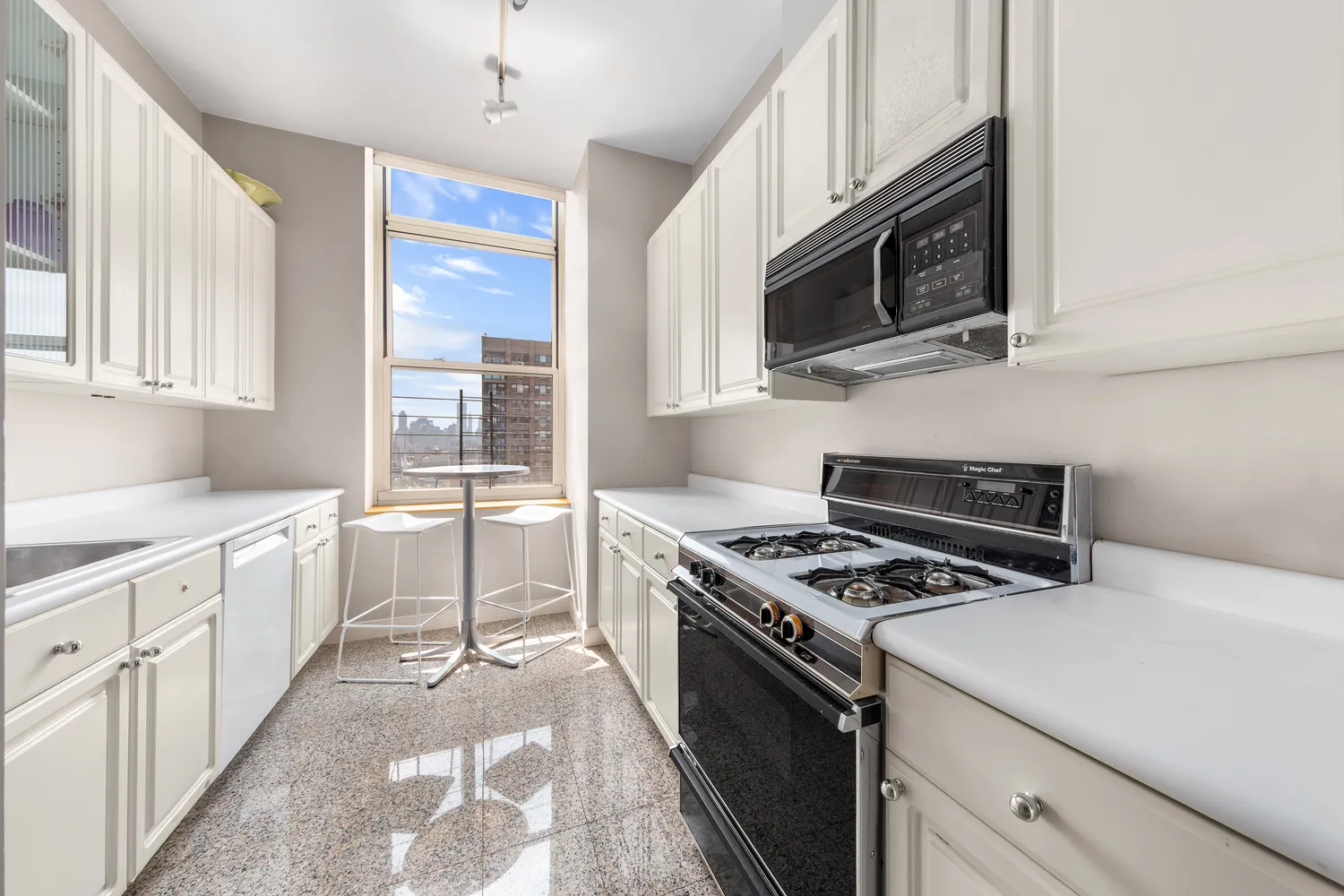 a kitchen with granite countertop a sink appliances and cabinets