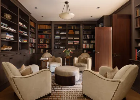 a living room with furniture a rug and a book shelf