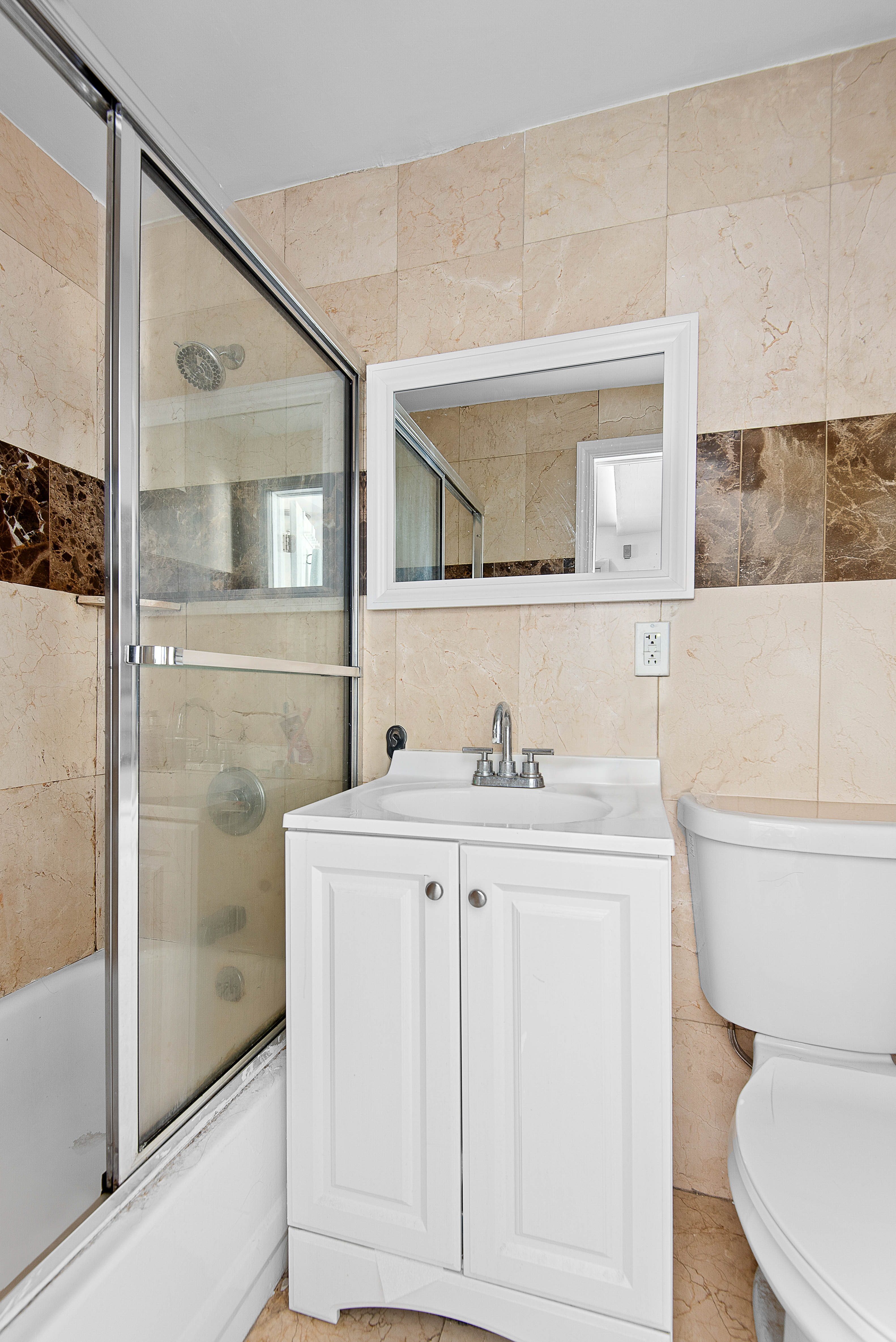 269 Ainslie Street, Unit 2 Brooklyn, NY 11211 - Photo 6 of 11 a bathroom with a toilet a sink and glass door