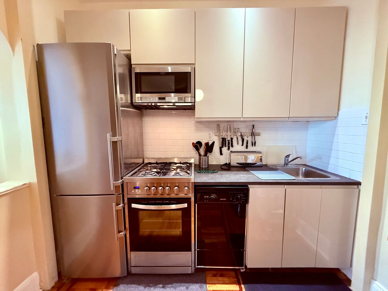 46 St Marks Place, Unit 7 Manhattan, NY 10003 - Photo 3 of 7 a kitchen with stainless steel appliances granite countertop a refrigerator stove a sink and a microwave