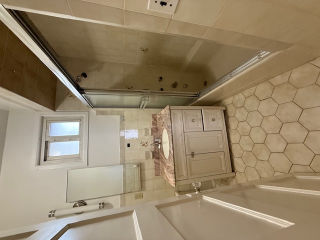 1587 East 18th Street, Unit 2 Brooklyn, NY 11230 - Photo 11 of 13 a bathroom with a sink a mirror and a shower