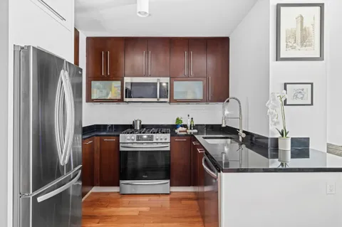 a kitchen with stainless steel appliances granite countertop a refrigerator stove and microwave