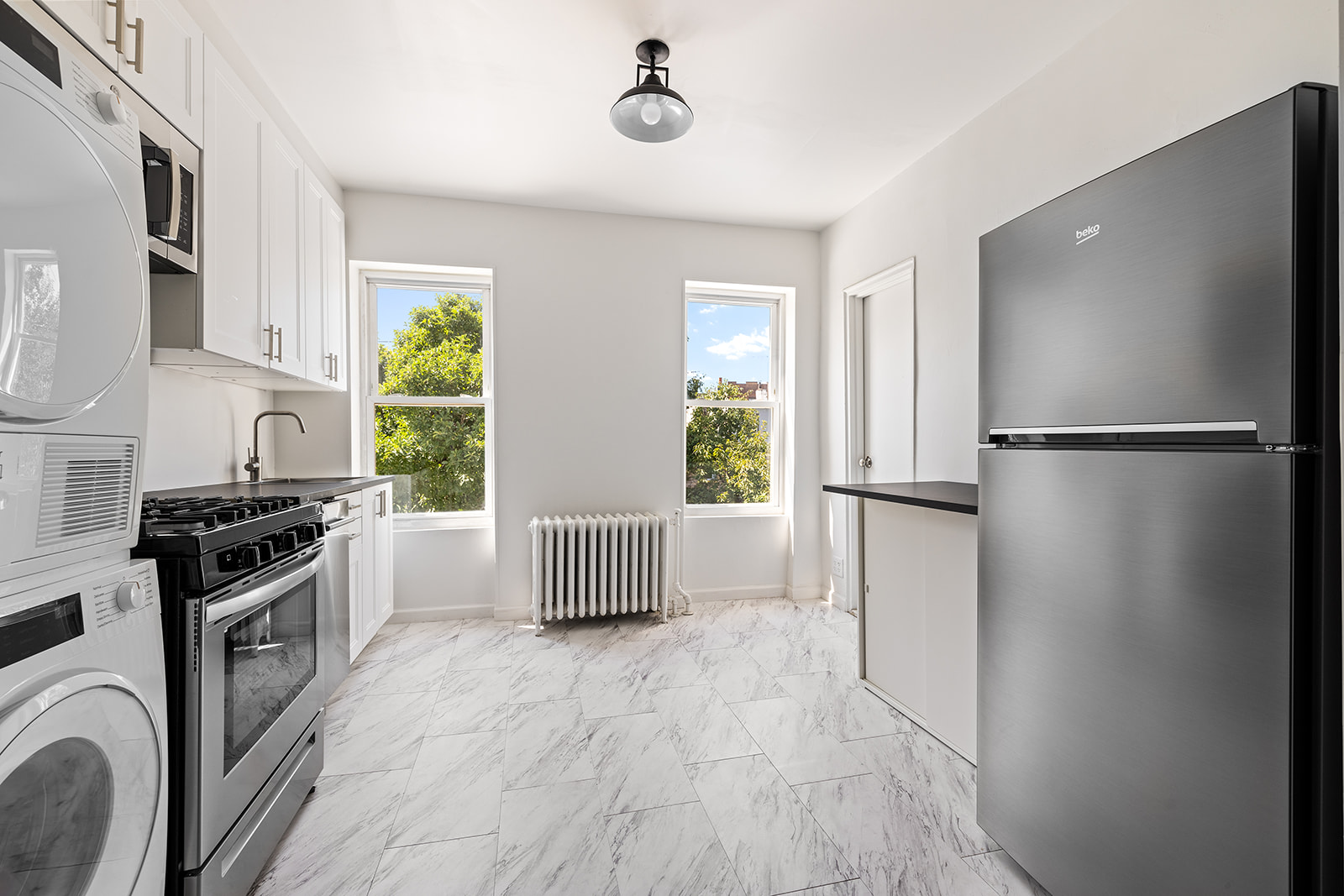 a kitchen with stainless steel appliances granite countertop a refrigerator a stove a sink and a window