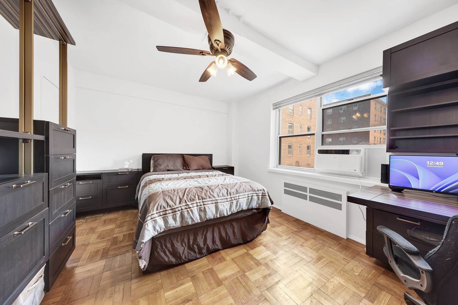 530 Grand Street, Unit E8C Manhattan, NY 10002 - Photo 5 of 15 a bedroom with a large bed and a flat tv screen