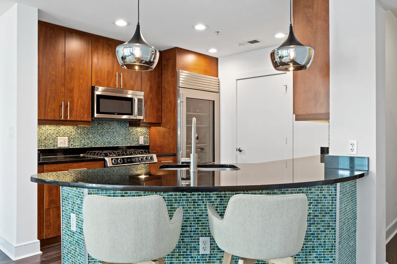 a kitchen with stainless steel appliances granite countertop a sink a microwave cabinets and a dining table