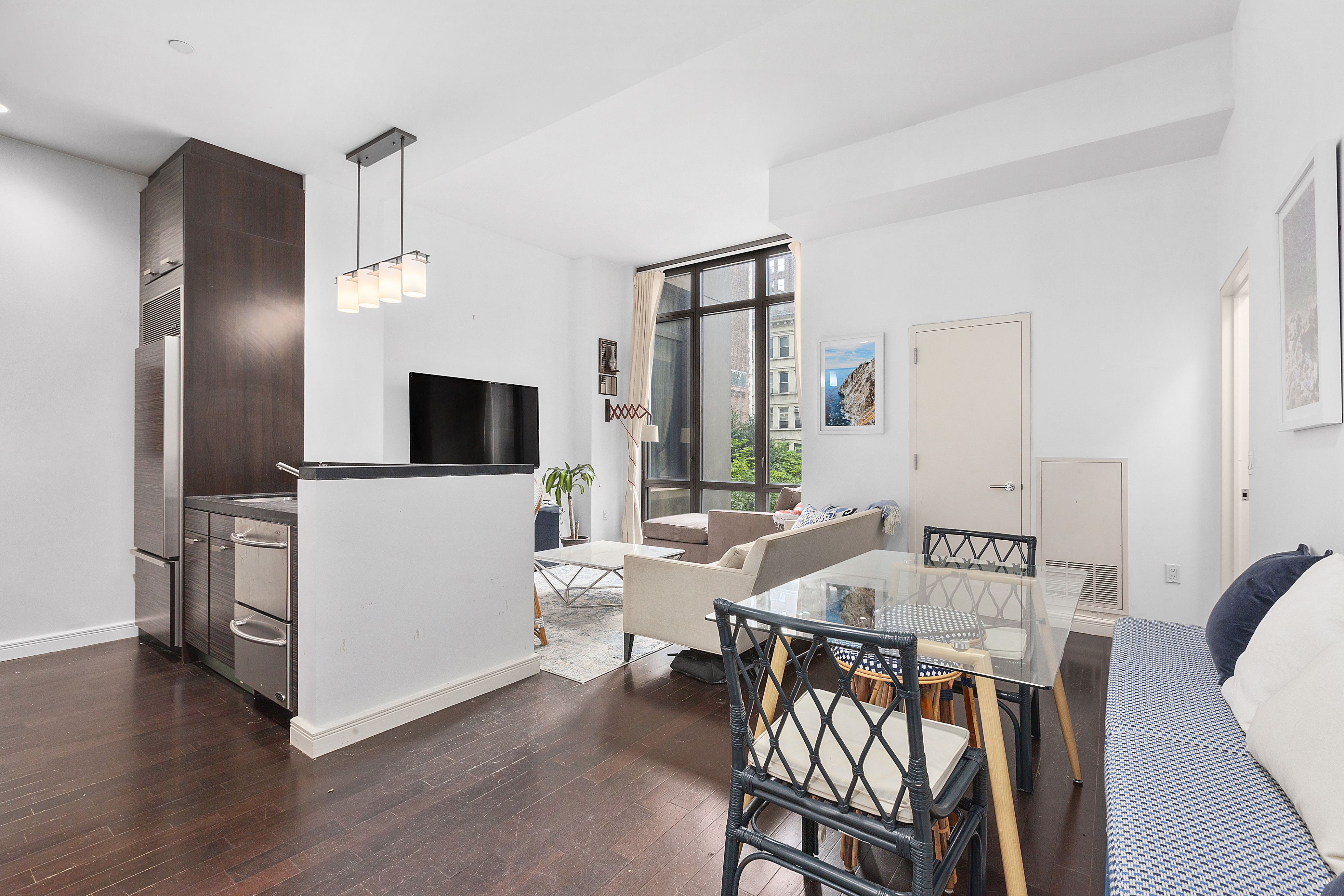 101 West 24th Street, Unit 4G Manhattan, NY 10011 - Photo 3 of 7 a living room with furniture and a flat screen tv