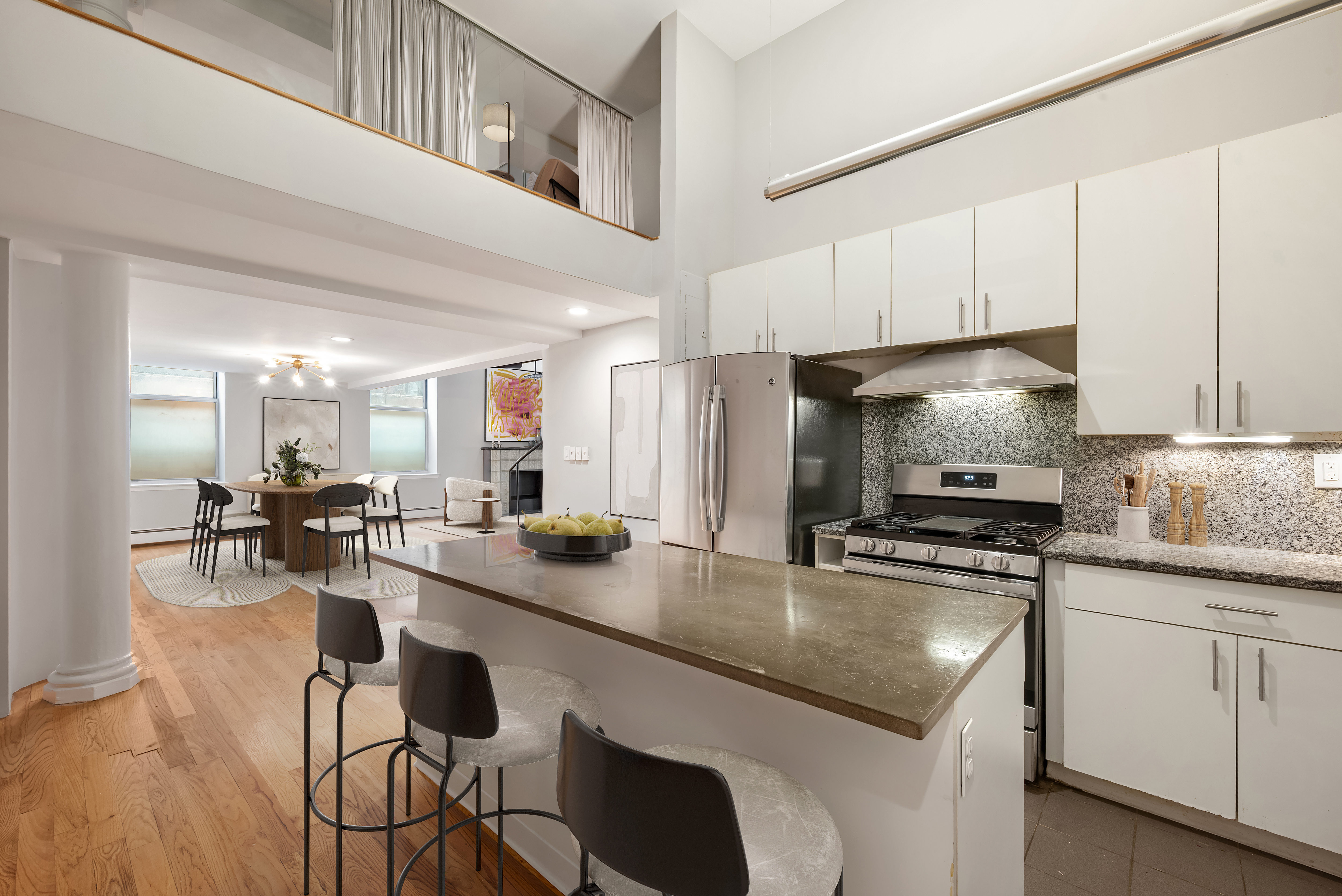 95 Greene Street, Unit 2F Manhattan, NY 10012 - Photo 3 of 8 a kitchen with a dining table chairs sink and cabinets