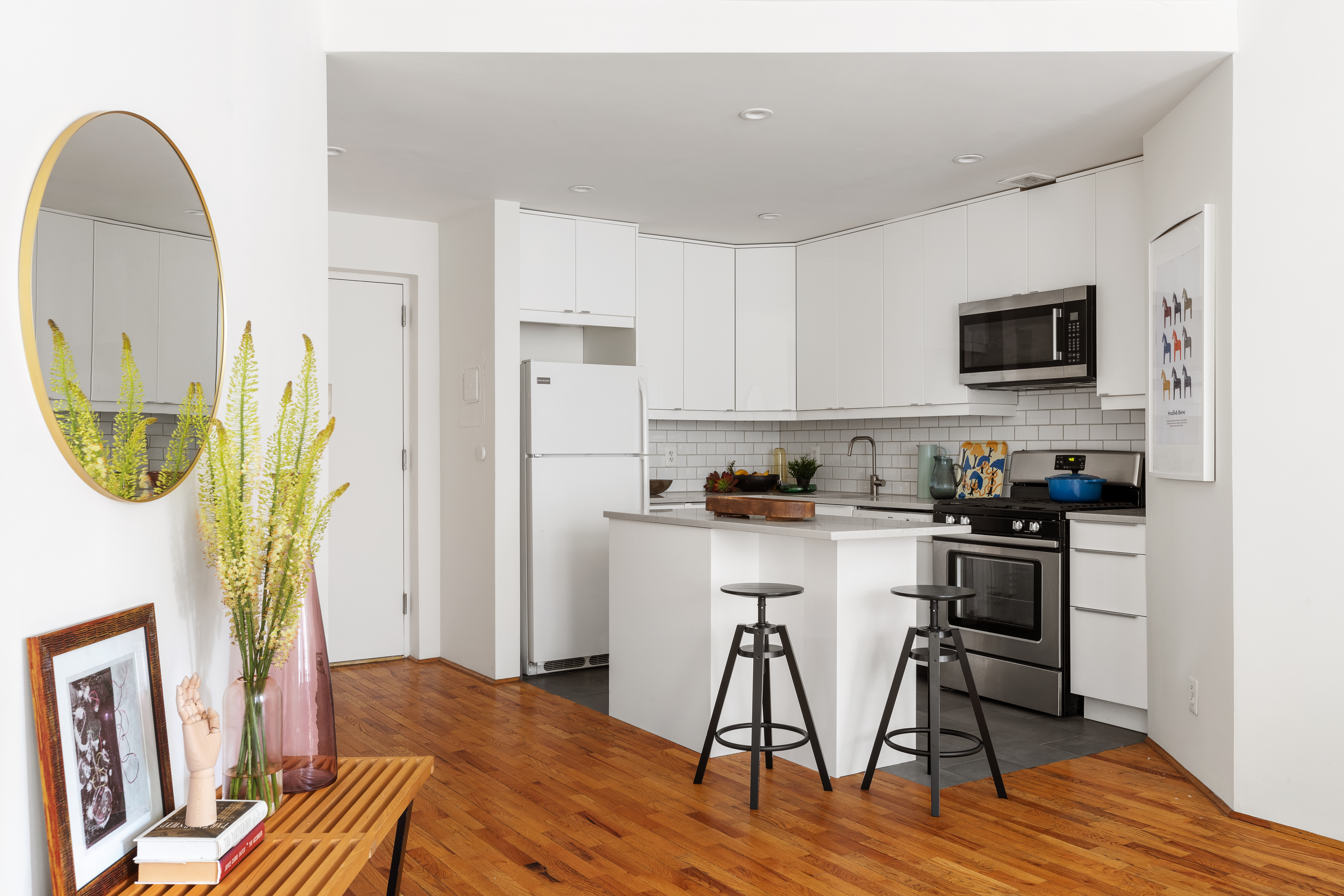 167 Perry Street, Unit 4K Manhattan, NY 10014 - Photo 4 of 11 a kitchen with a table chairs refrigerator and microwave