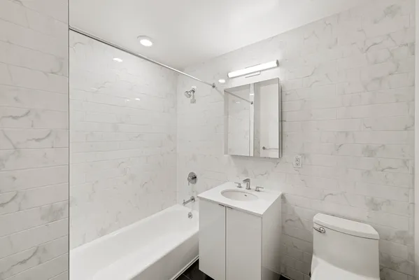 a bathroom with a sink toilet tub and shower