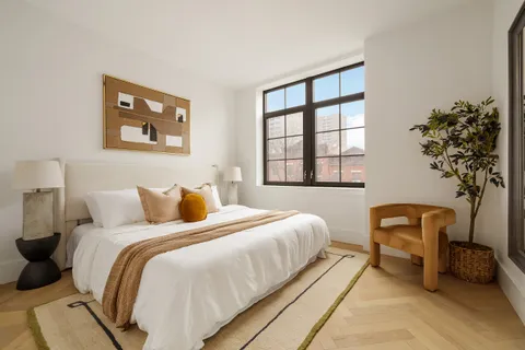 a bedroom with bed and a potted plant