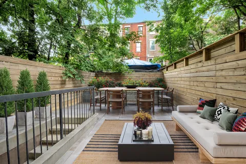 a view of a patio with couches table and chairs and potted plants