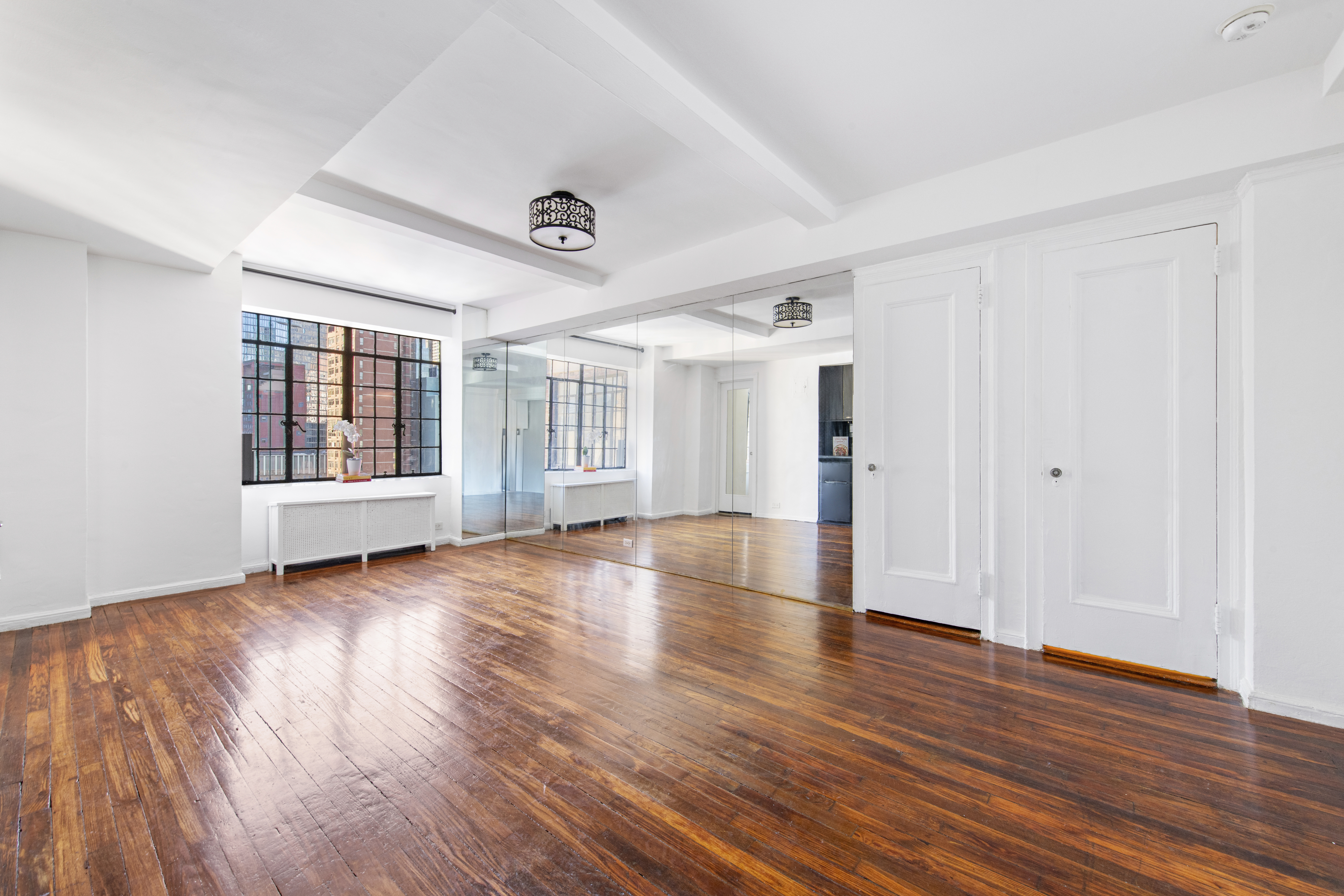 45 Tudor City Place, Unit 1808 Manhattan, NY 10017 - Photo 3 of 10 an empty room with wooden floor and windows