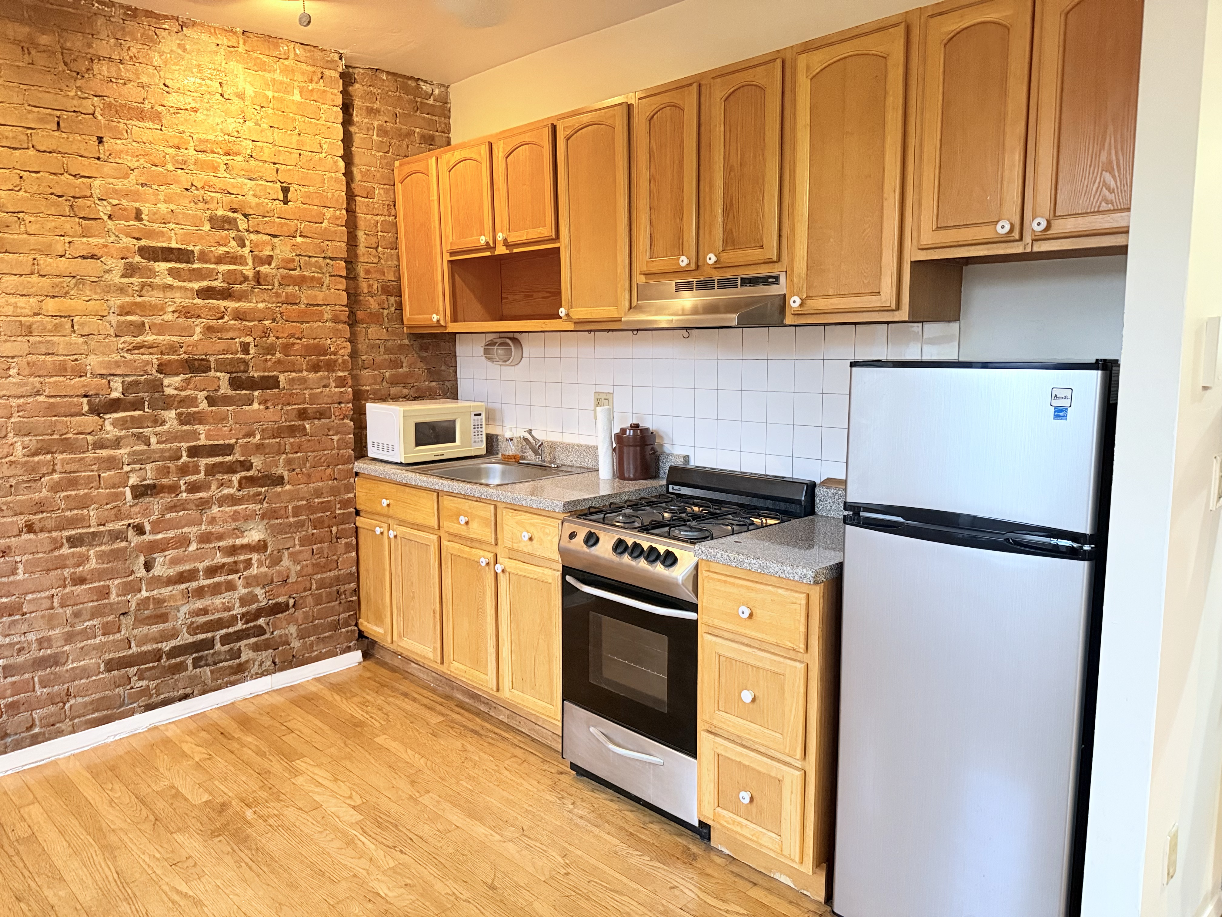 1672 Park Avenue, Unit 4A Manhattan, NY 10035 - Photo 8 of 11 a kitchen with stainless steel appliances a stove a sink and a refrigerator