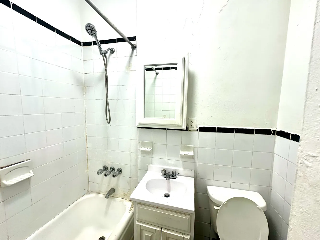 a bathroom with a sink and mirror with bathtub