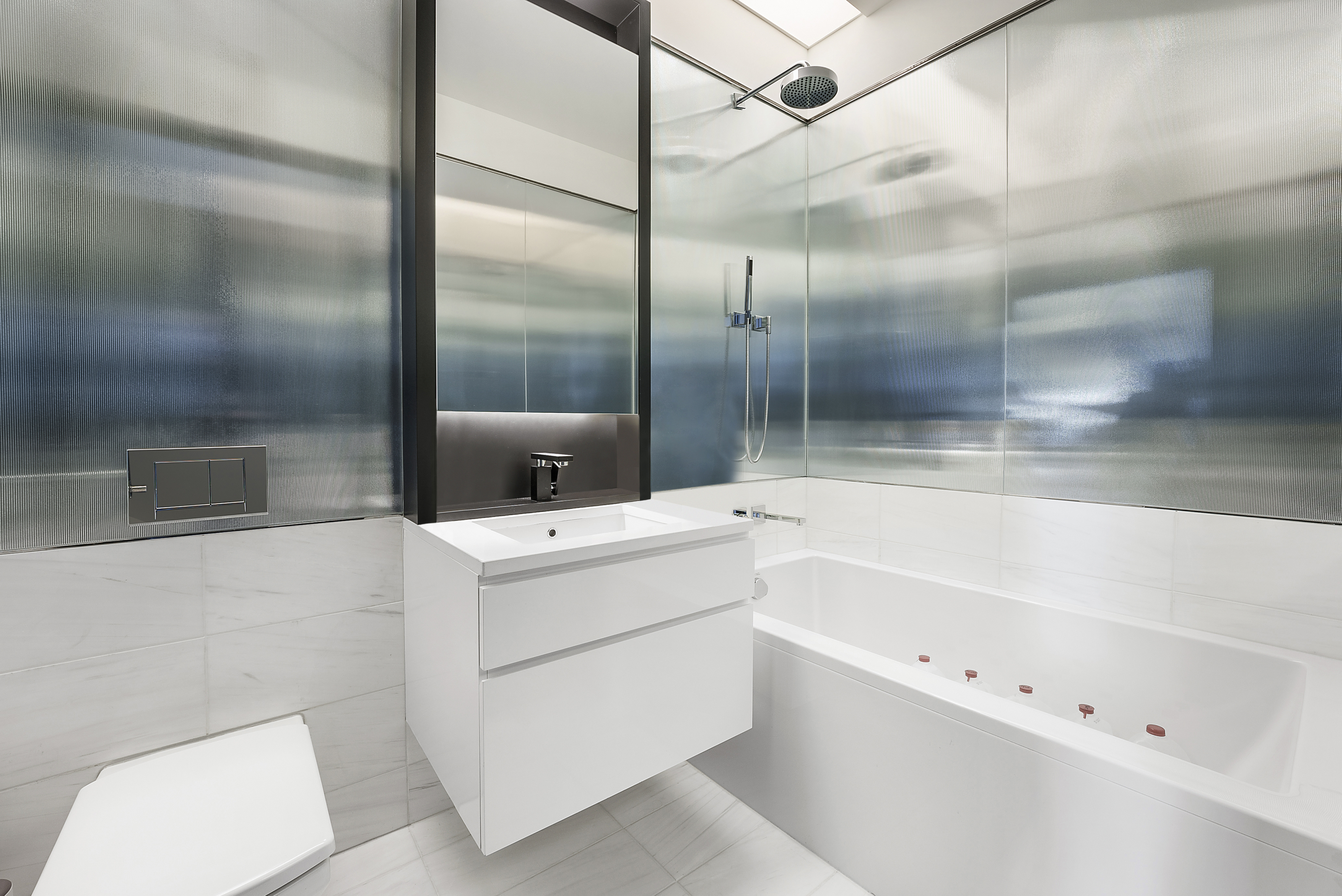 157 West 57th Street, Unit 49B Manhattan, NY 10019 - Photo 7 of 9 a bathroom with a bathtub and a shower