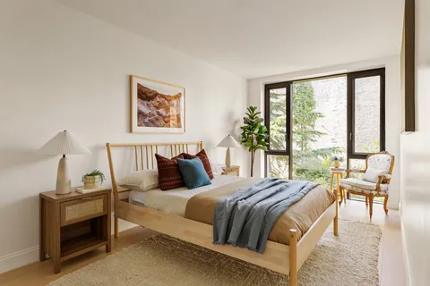 a bedroom with a bed and a large window