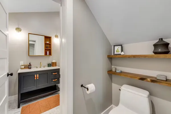 a bathroom with a sink a toilet and mirror