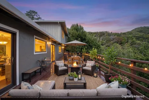 a view of a patio with couches table and chairs with wooden floor and fence