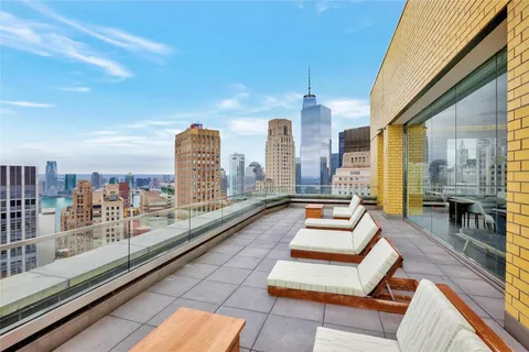 a view of a city from a balcony with furniture
