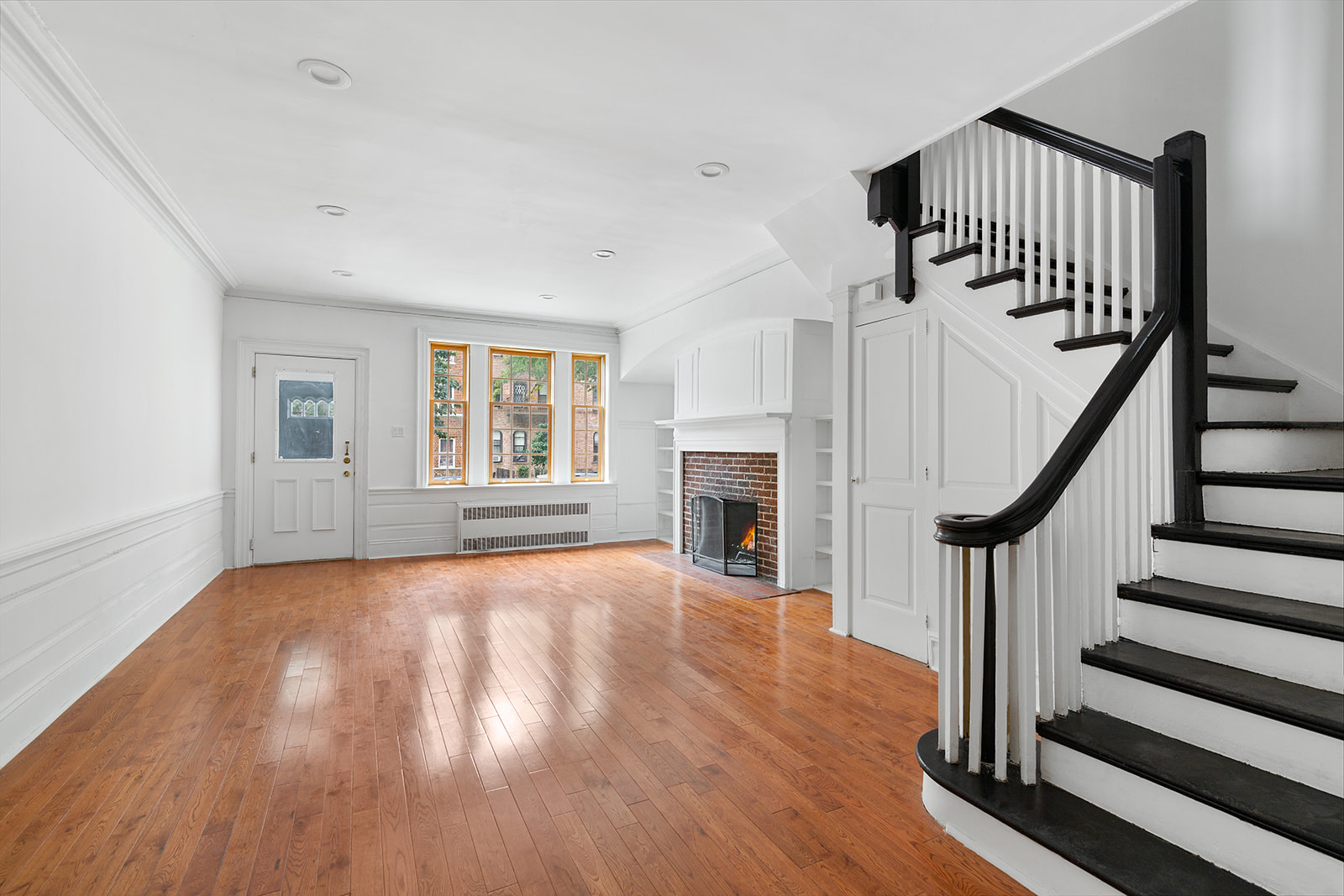 165 Fenimore Street Brooklyn, NY 11225 - Photo 1 of 13 a view of an empty room with wooden floor fireplace and a window