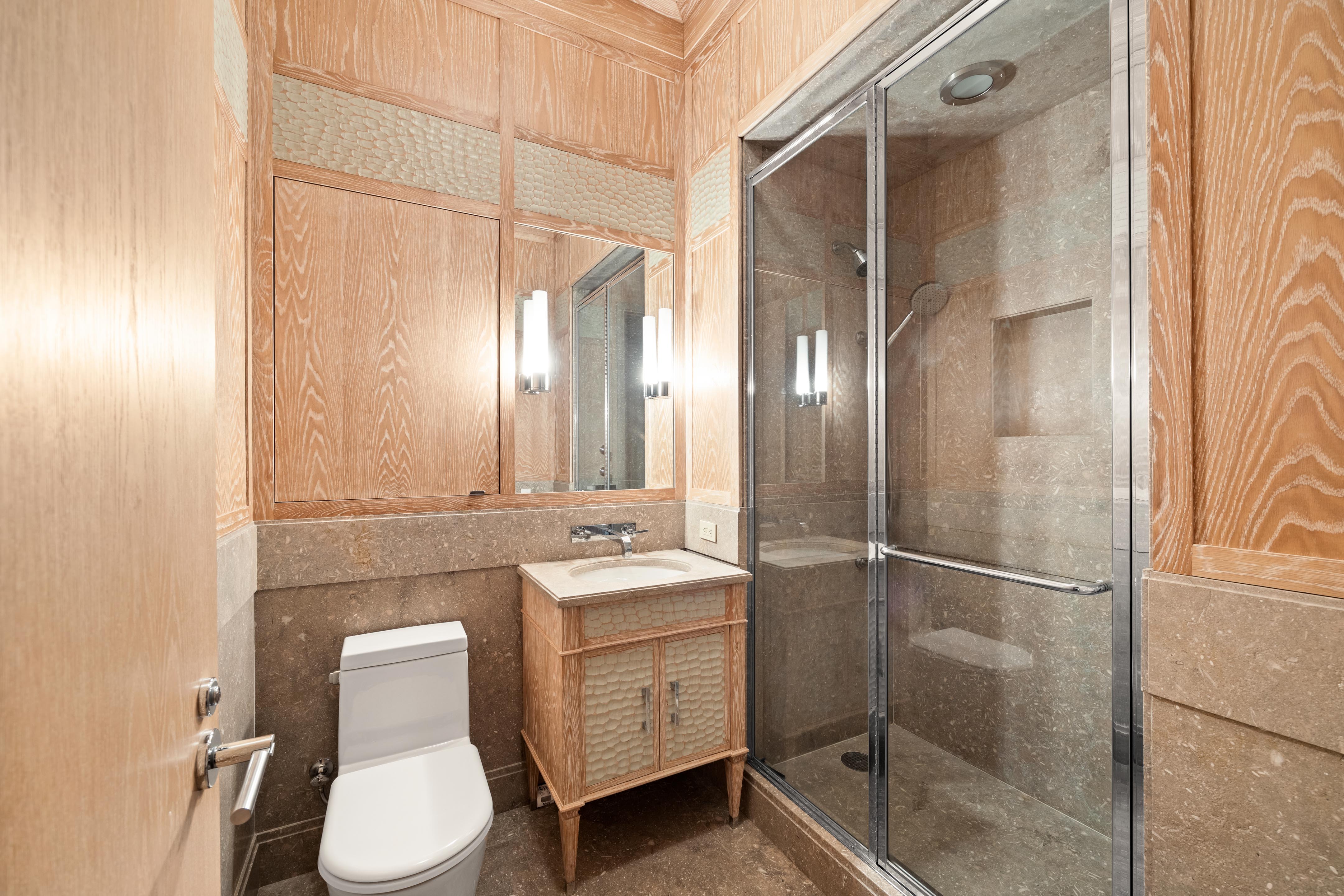 25 Columbus Circle, Unit 75A Manhattan, NY 10019 - Photo 12 of 36 a bathroom with a toilet a sink and mirror