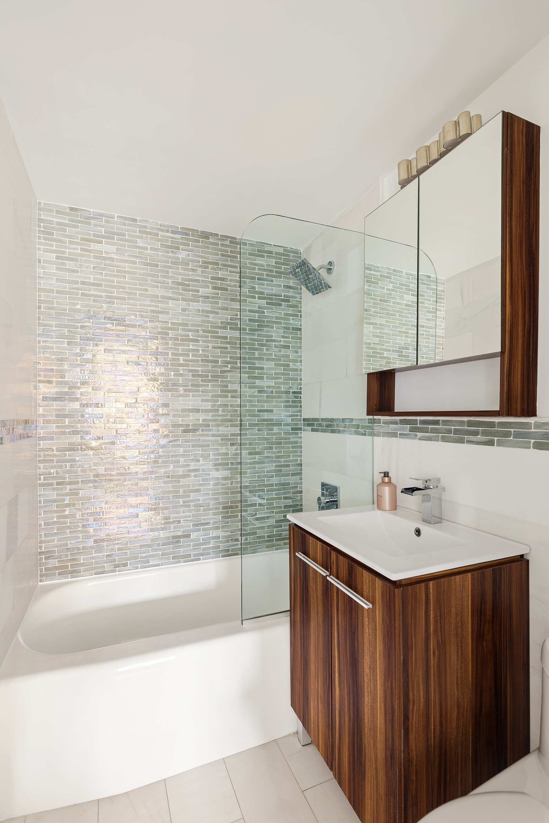 10 East End Avenue, Unit 18D Manhattan, NY 10075 - Photo 16 of 21 a bathroom with a sink a mirror and a bathtub