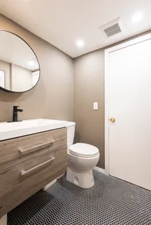 a bathroom with a sink a toilet and a mirror
