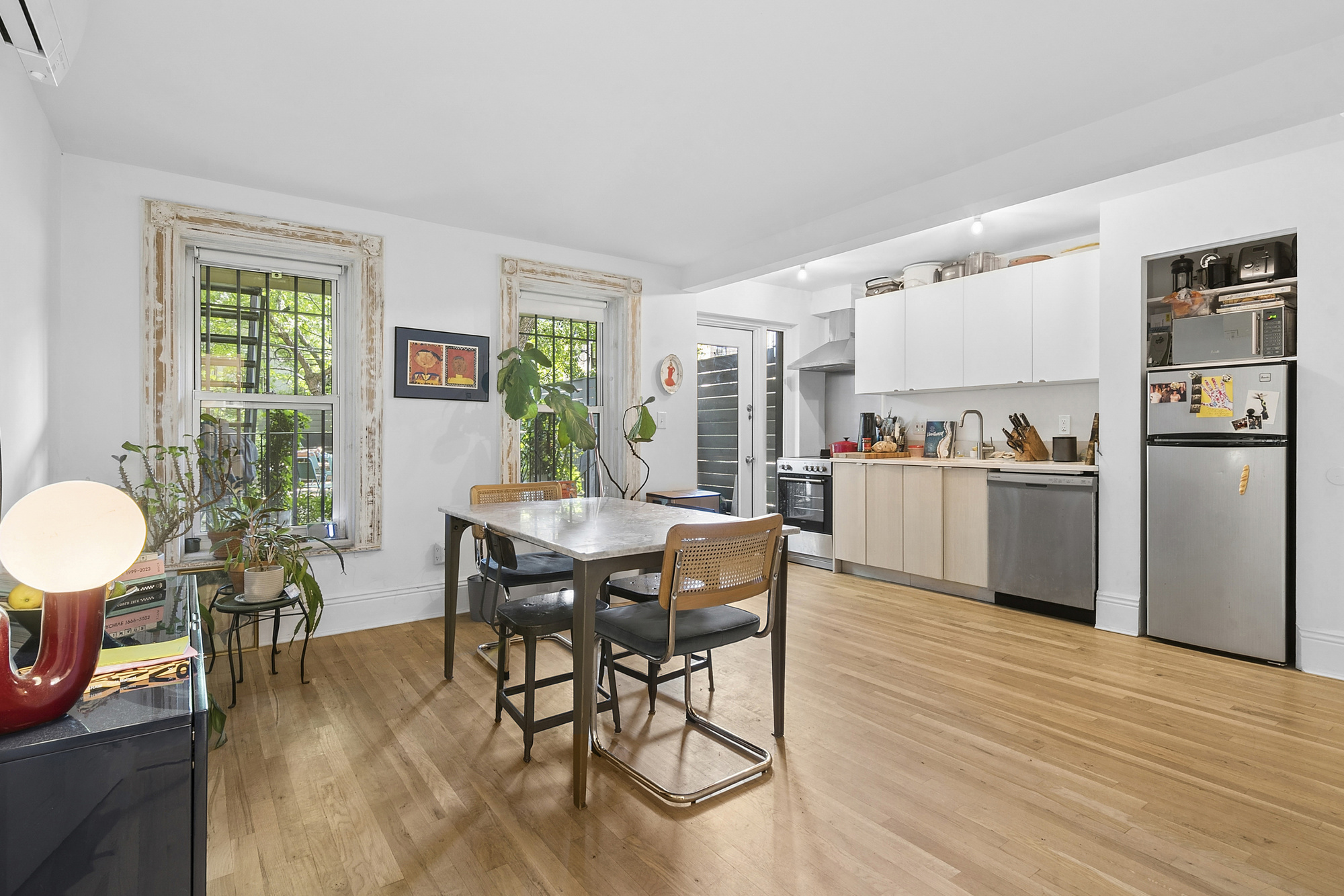 576 A MacDonough Street, Unit 1 Brooklyn, NY 11233 - Photo 1 of 6 a living room with stainless steel appliances furniture a dining table and a window