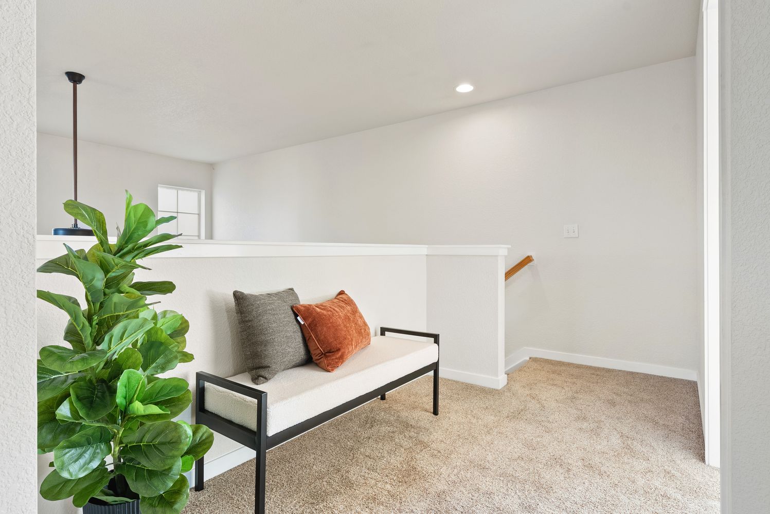 a living room with furniture and a potted plant
