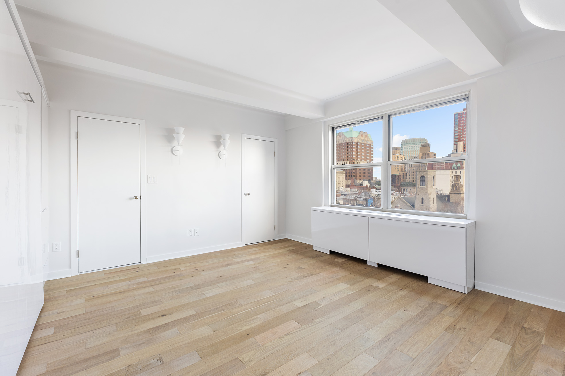 70 Remsen Street, Unit 10J Brooklyn, NY 11201 - Photo 4 of 11 an empty room with wooden floor and windows