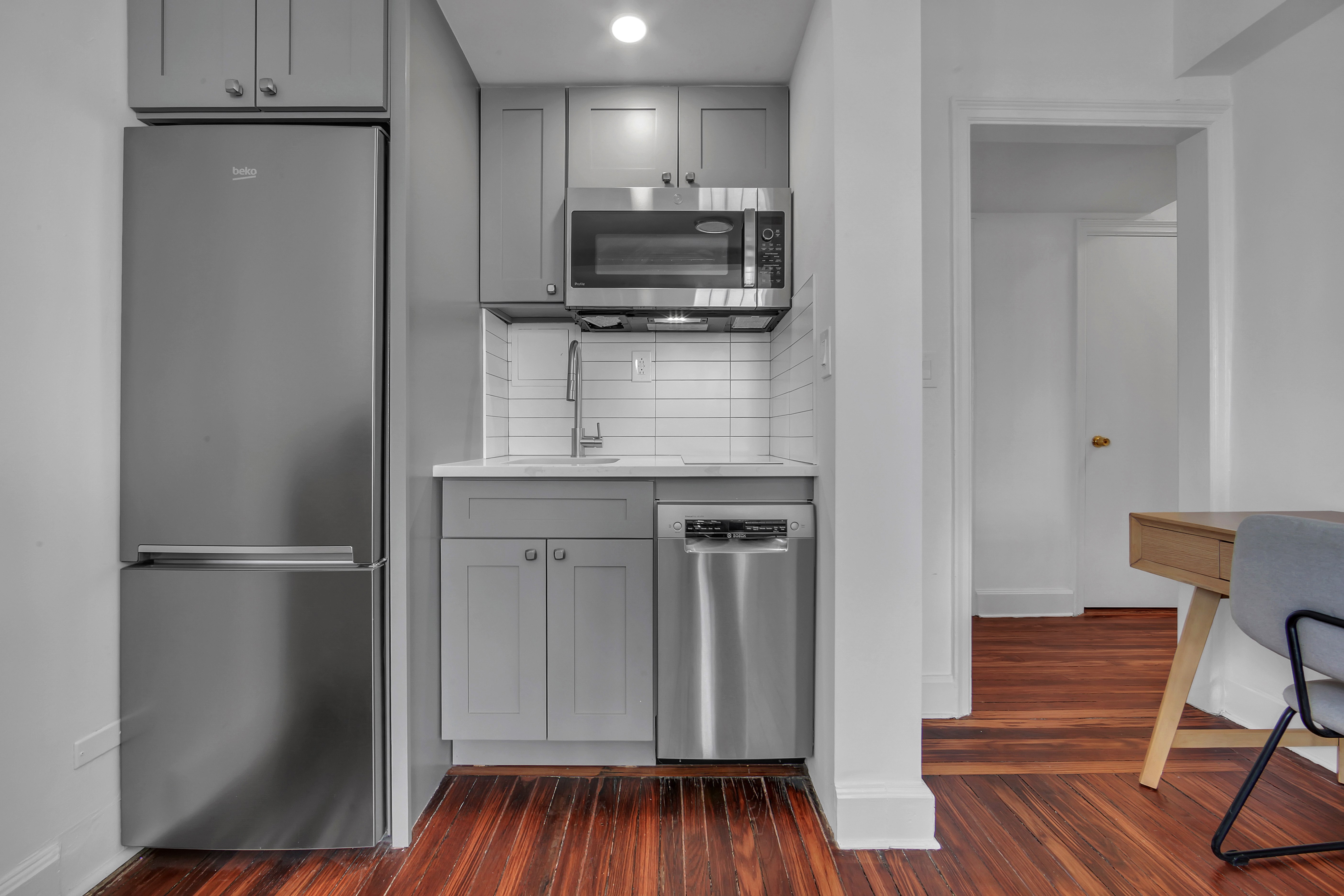 5 Tudor City Place, Unit 1536 Manhattan, NY 10017 - Photo 9 of 21 a kitchen with kitchen island a counter top space a sink and a refrigerator