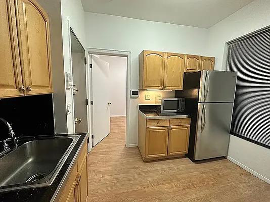 1313 3rd Avenue, Unit PH5 Manhattan, NY 10021 - Photo 3 of 5 a kitchen with granite countertop a refrigerator stove and sink