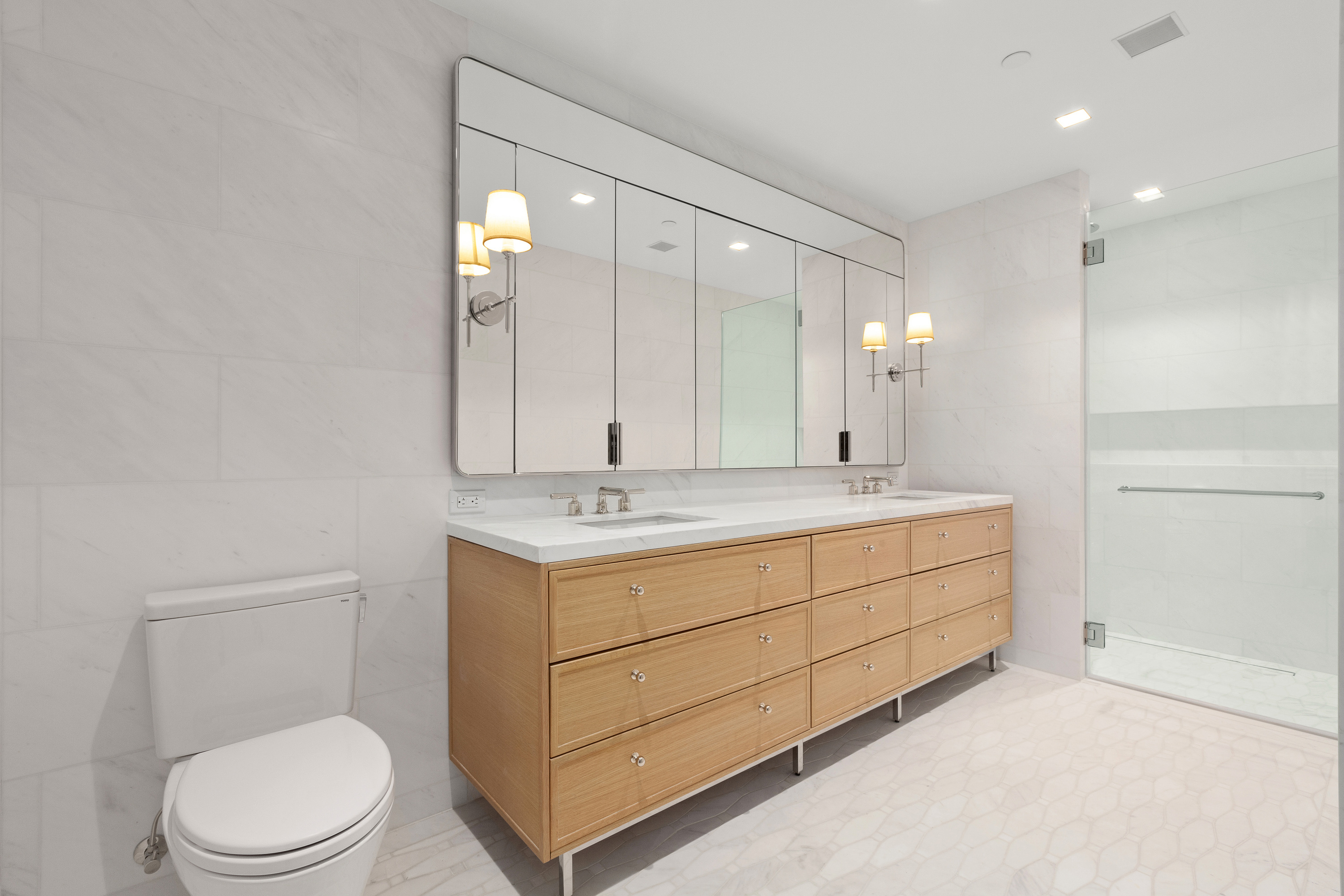 200 East 83rd Street, Unit 5D Manhattan, NY 10028 - Photo 10 of 29 a bathroom with a toilet a sink and mirror