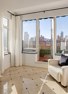 a living room with furniture and a floor to ceiling window