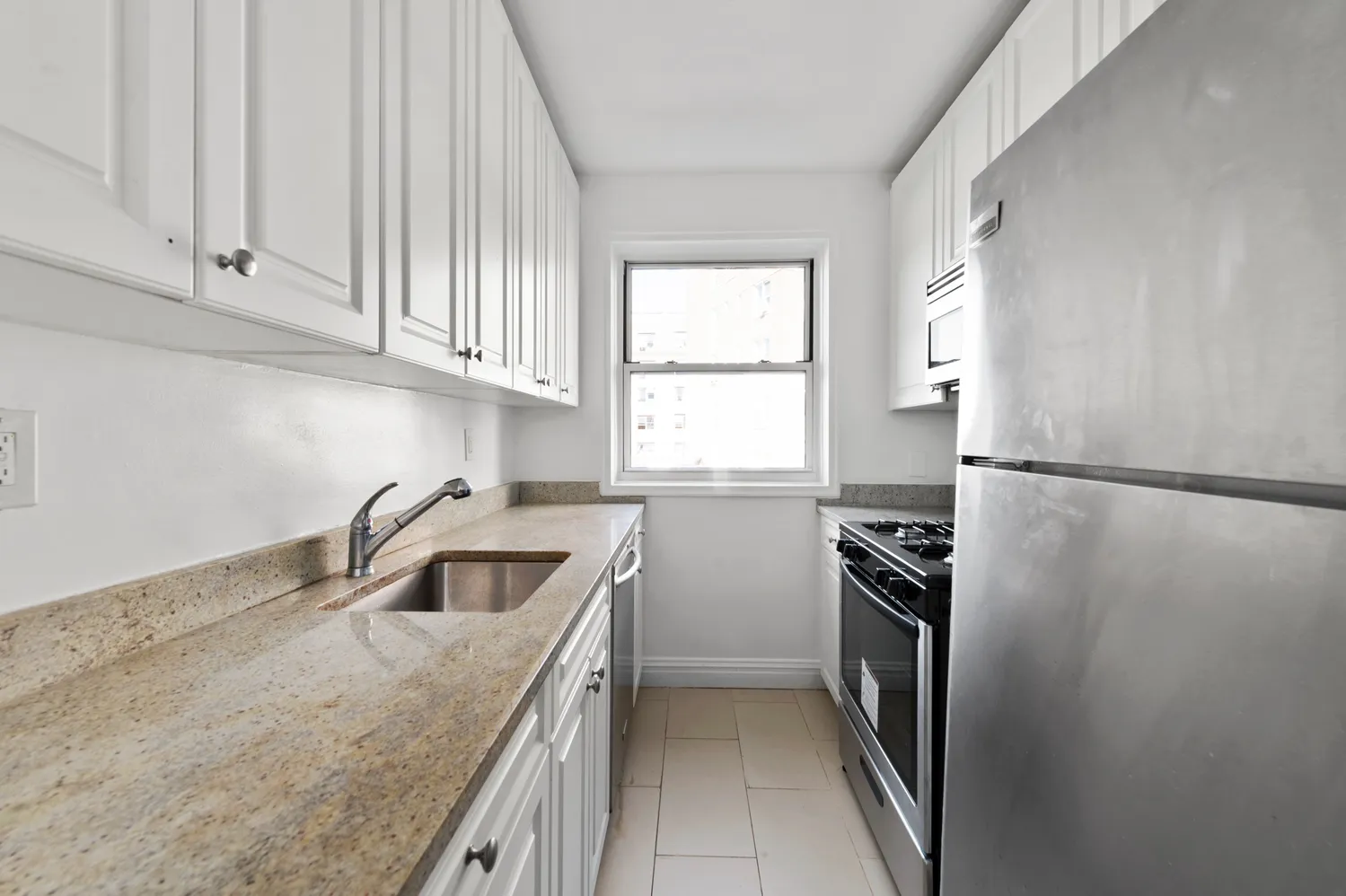 a kitchen with a refrigerator sink and cabinets
