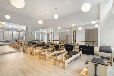 a living room with couches and kitchen view with wooden floor