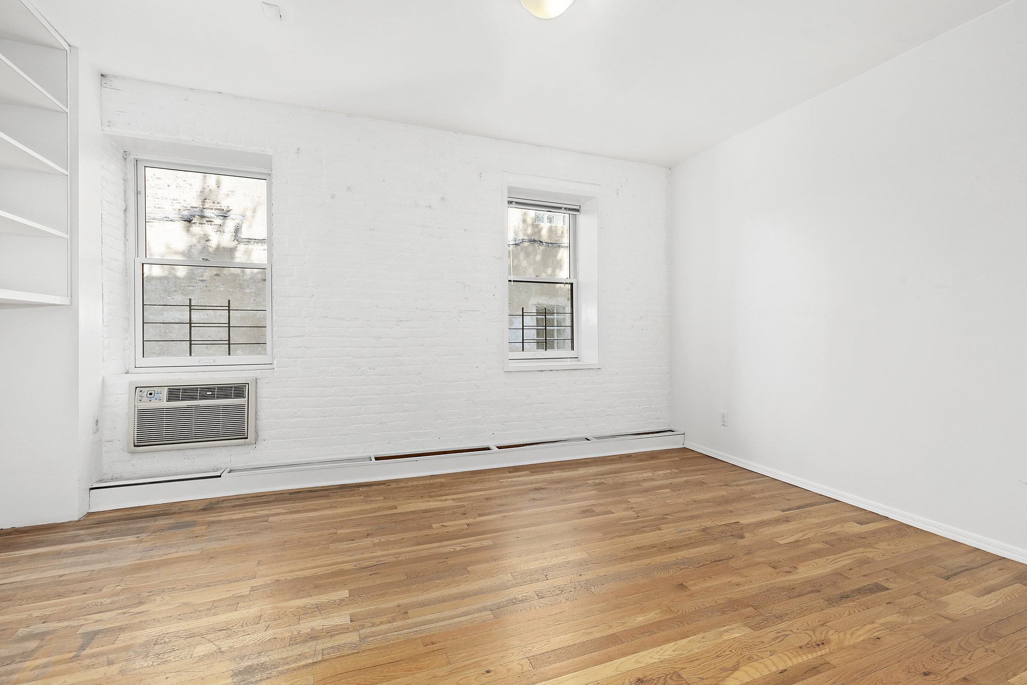 7 Worth Street, Unit 4B Manhattan, NY 10013 - Photo 4 of 7 an empty room with wooden floor and windows