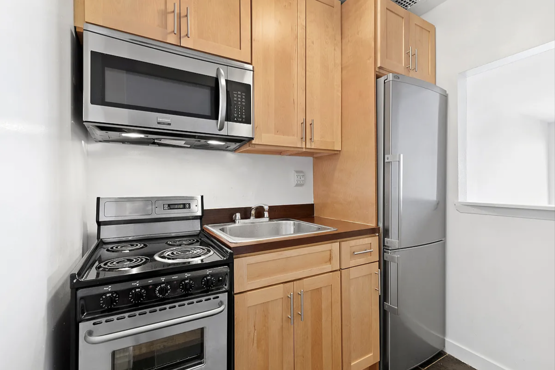 343 East 76th Street, Unit 1B Manhattan, NY 10021 - Photo 3 of 5 a kitchen with a stove and a microwave