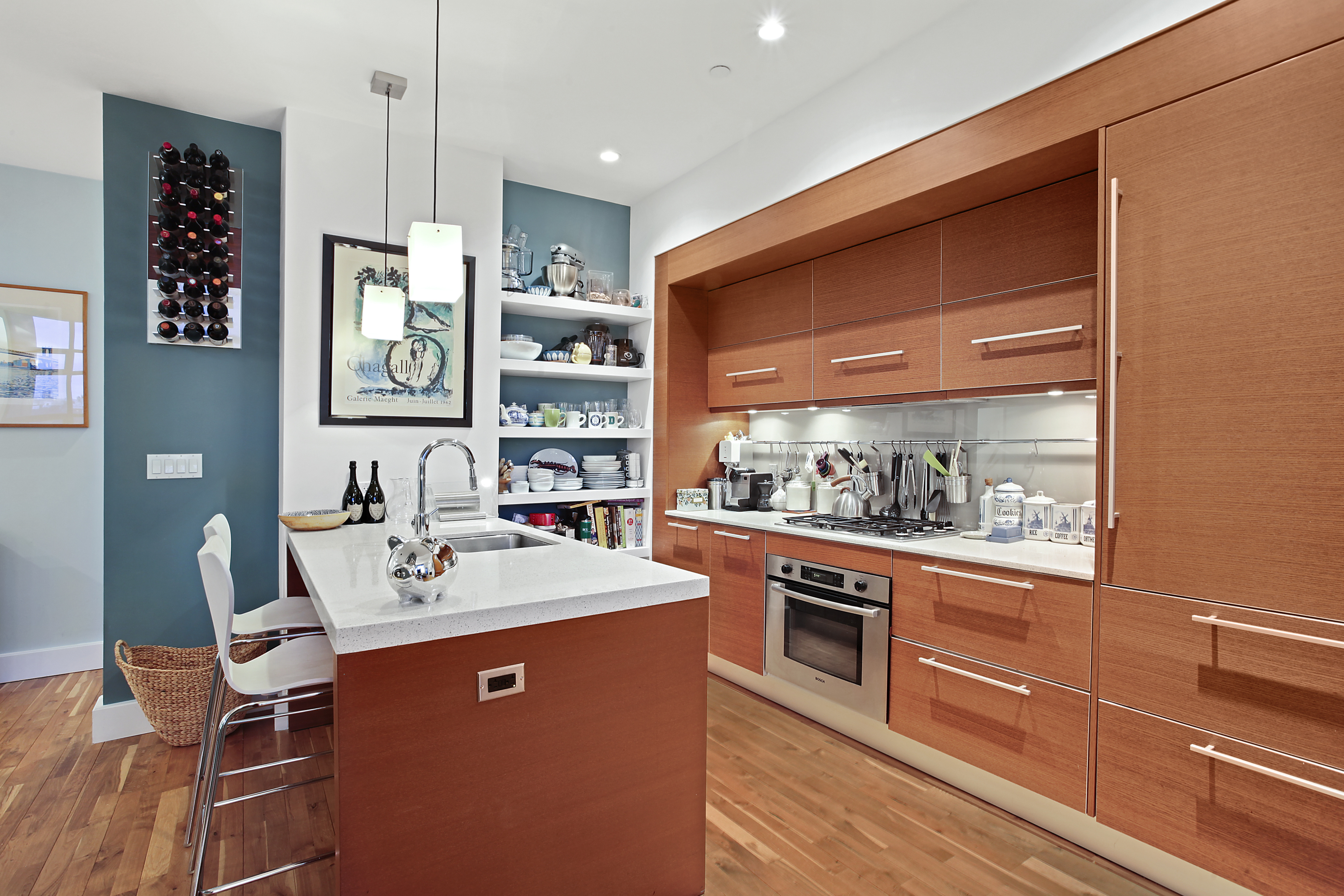 360 Furman Street, Unit 723/724 Brooklyn, NY 11201 - Photo 12 of 63 a kitchen with stainless steel appliances kitchen island granite countertop a sink and wooden cabinets