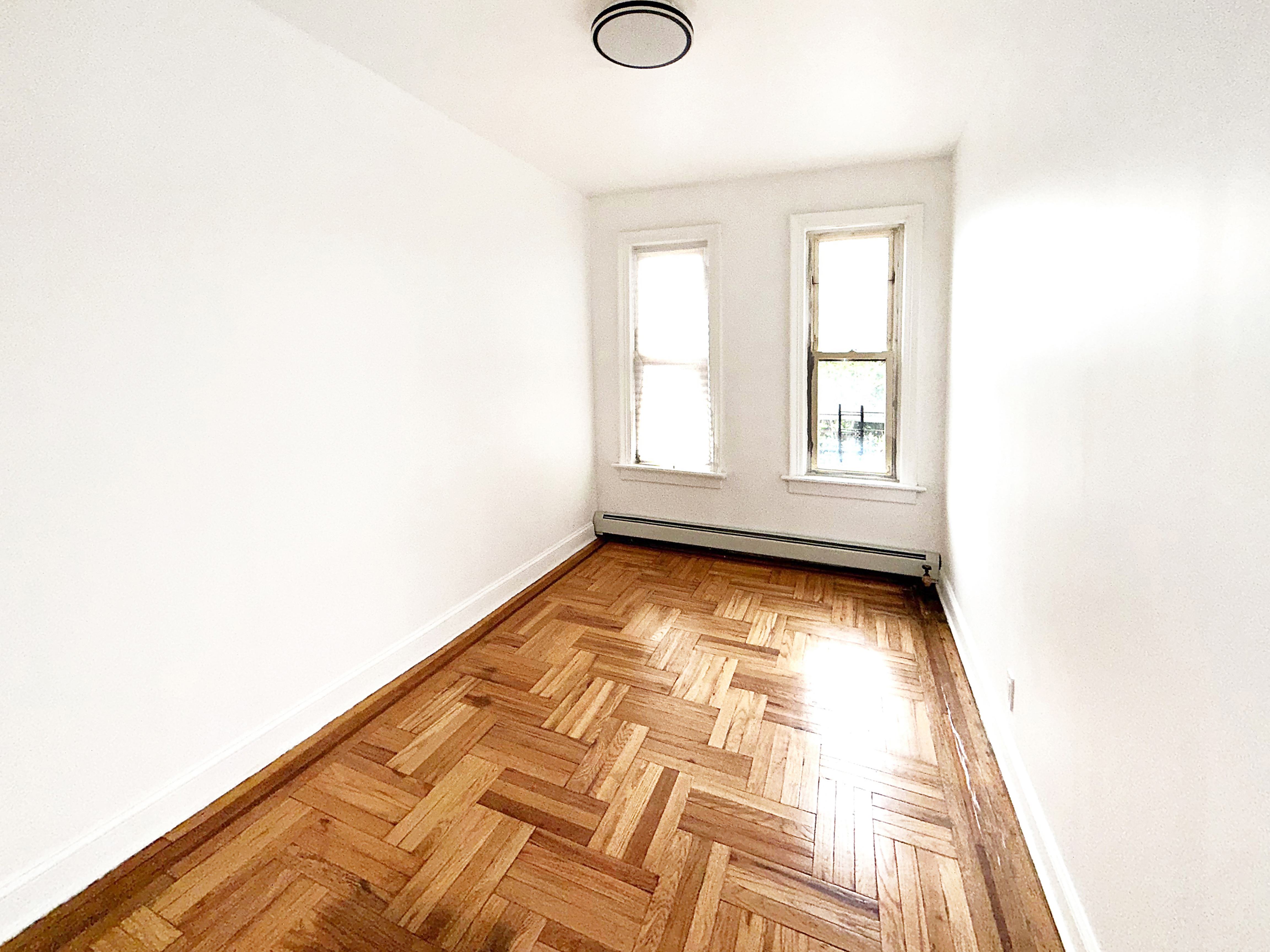 319 East 49th Street, Unit 1 Brooklyn, NY 11203 - Photo 7 of 8 a view of empty room with wooden floor and fan