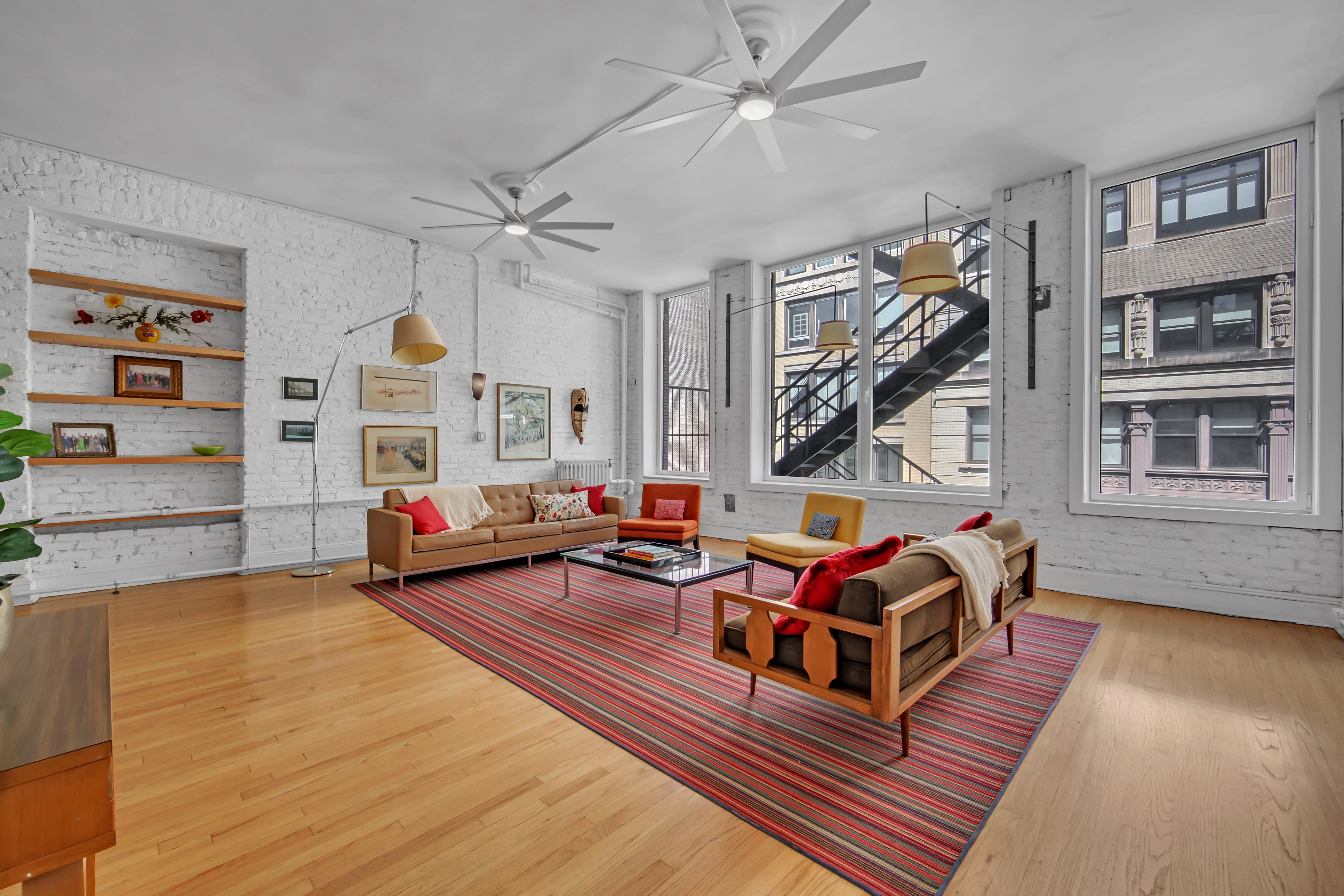 56 East 11th Street, Unit 7 Manhattan, NY 10003 - Photo 3 of 16 a living room with furniture a flat screen tv and a window