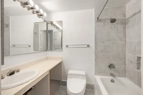 a bathroom with a sink a toilet and shower