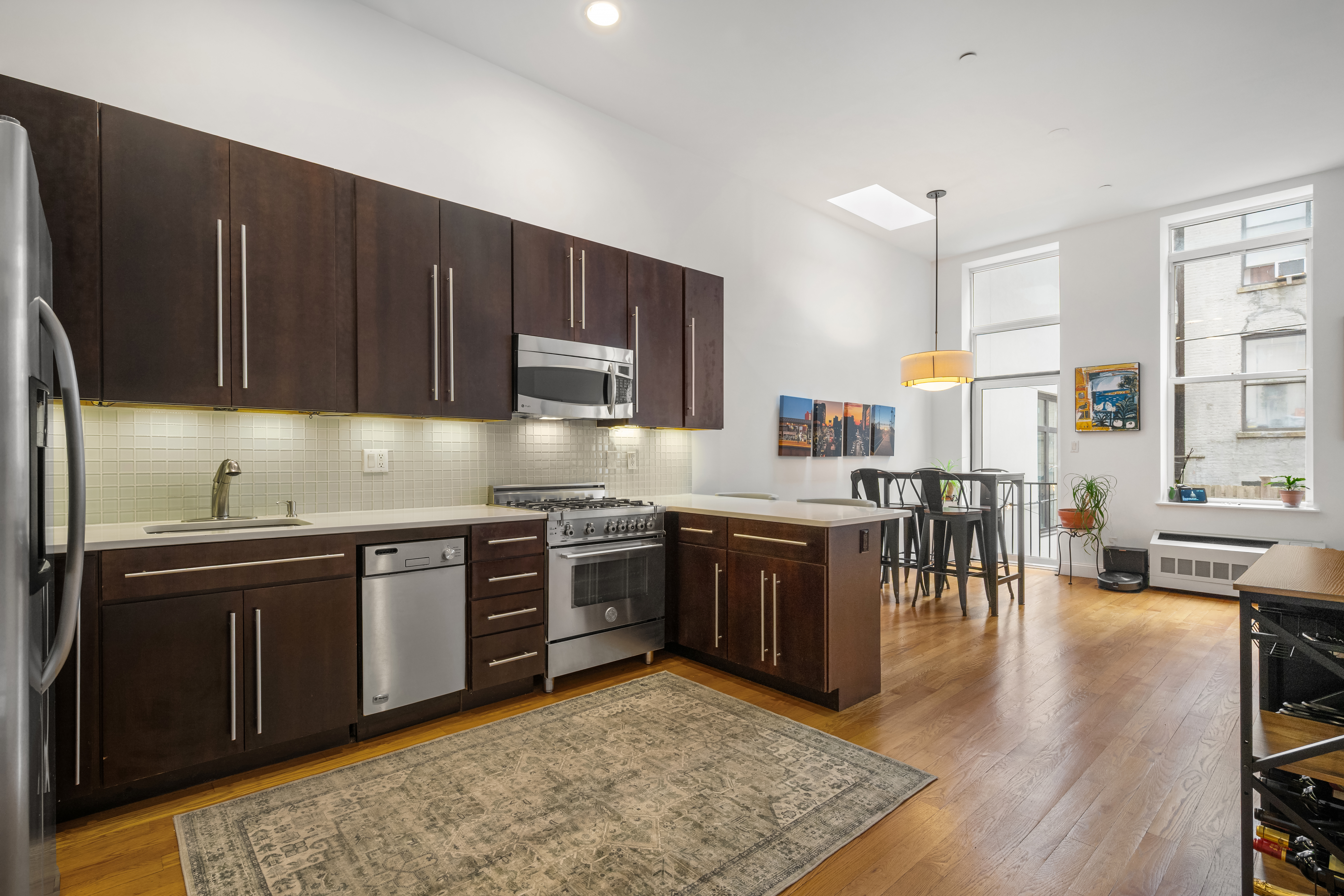 302 West 122nd Street, Unit 1 Manhattan, NY 10027 - Photo 4 of 13 a kitchen with stainless steel appliances granite countertop a refrigerator a stove top oven a sink and dishwasher