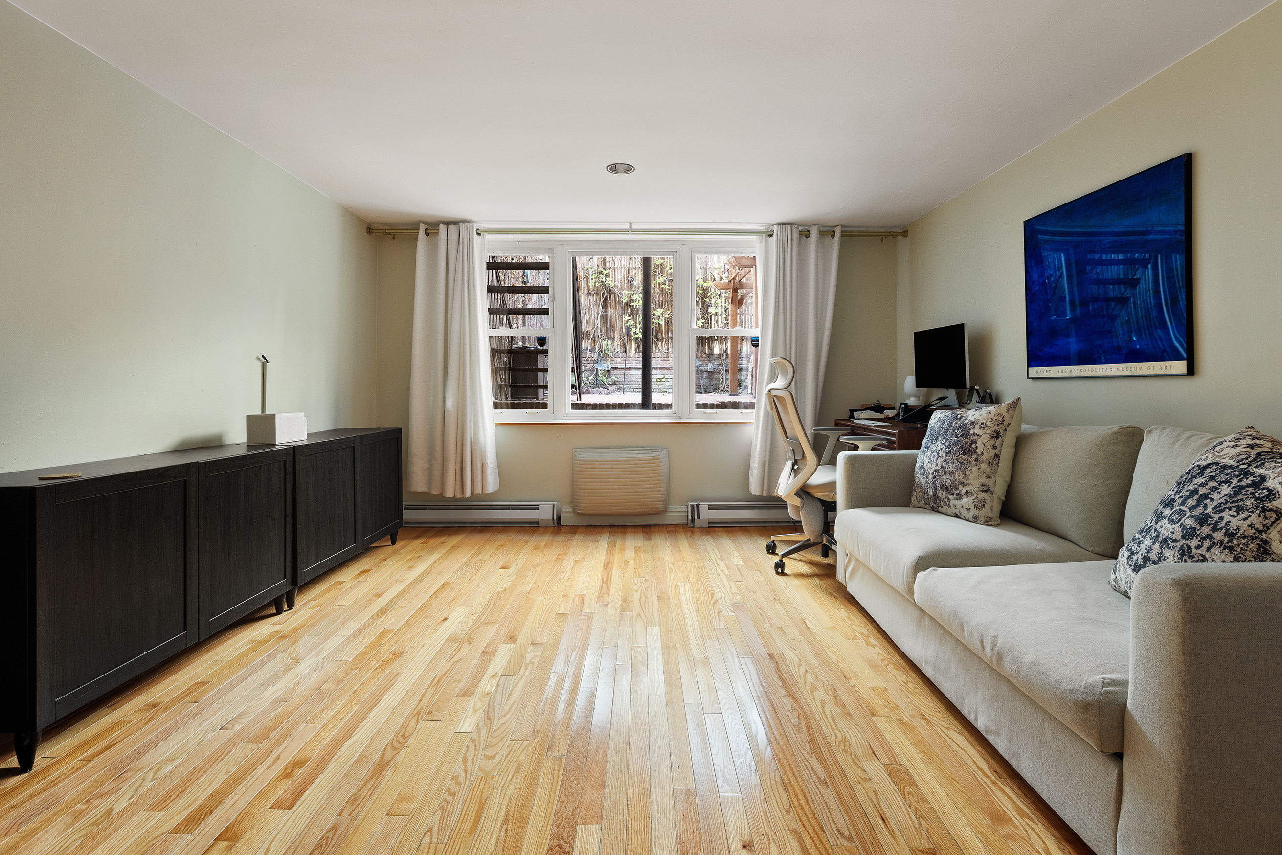 341 West 29th Street, Unit 1 Manhattan, NY 10001 - Photo 5 of 11 a living room with a couch wooden floor and a window