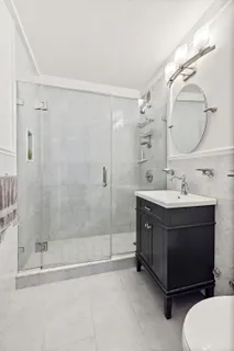 a bathroom with a double vanity sink mirror and shower
