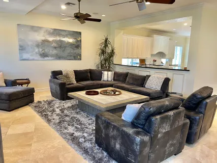 a living room with furniture and a view of kitchen