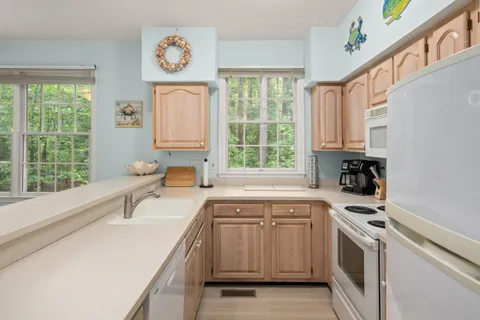 a kitchen with a stove a sink and a window
