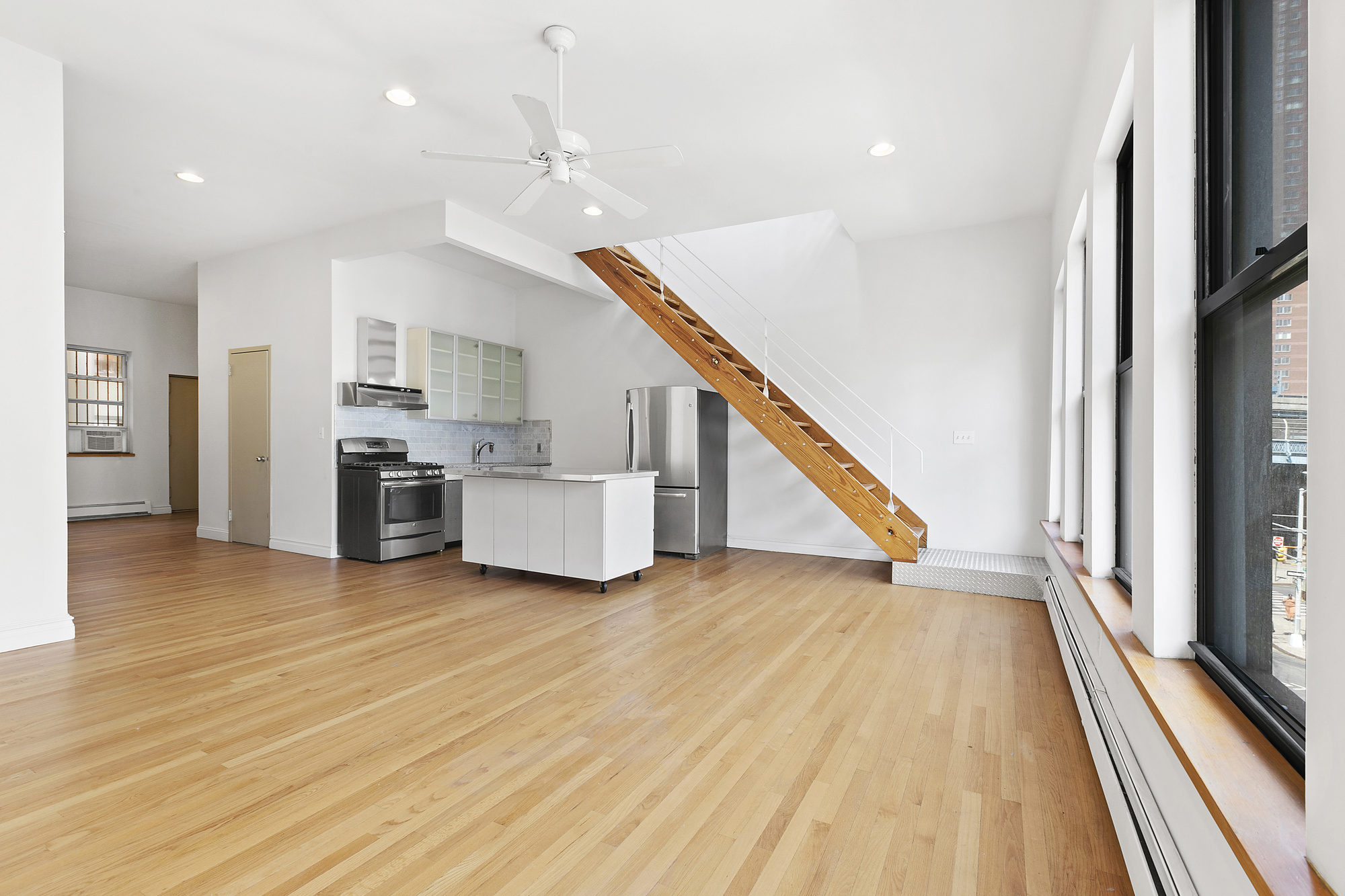 85 Division Street, Unit 4 Manhattan, NY 10002 - Photo 2 of 22 a view of a kitchen with furniture and an empty room