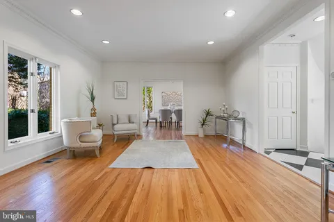 a dining room with wooden floor a chandelier a glass table and chairs