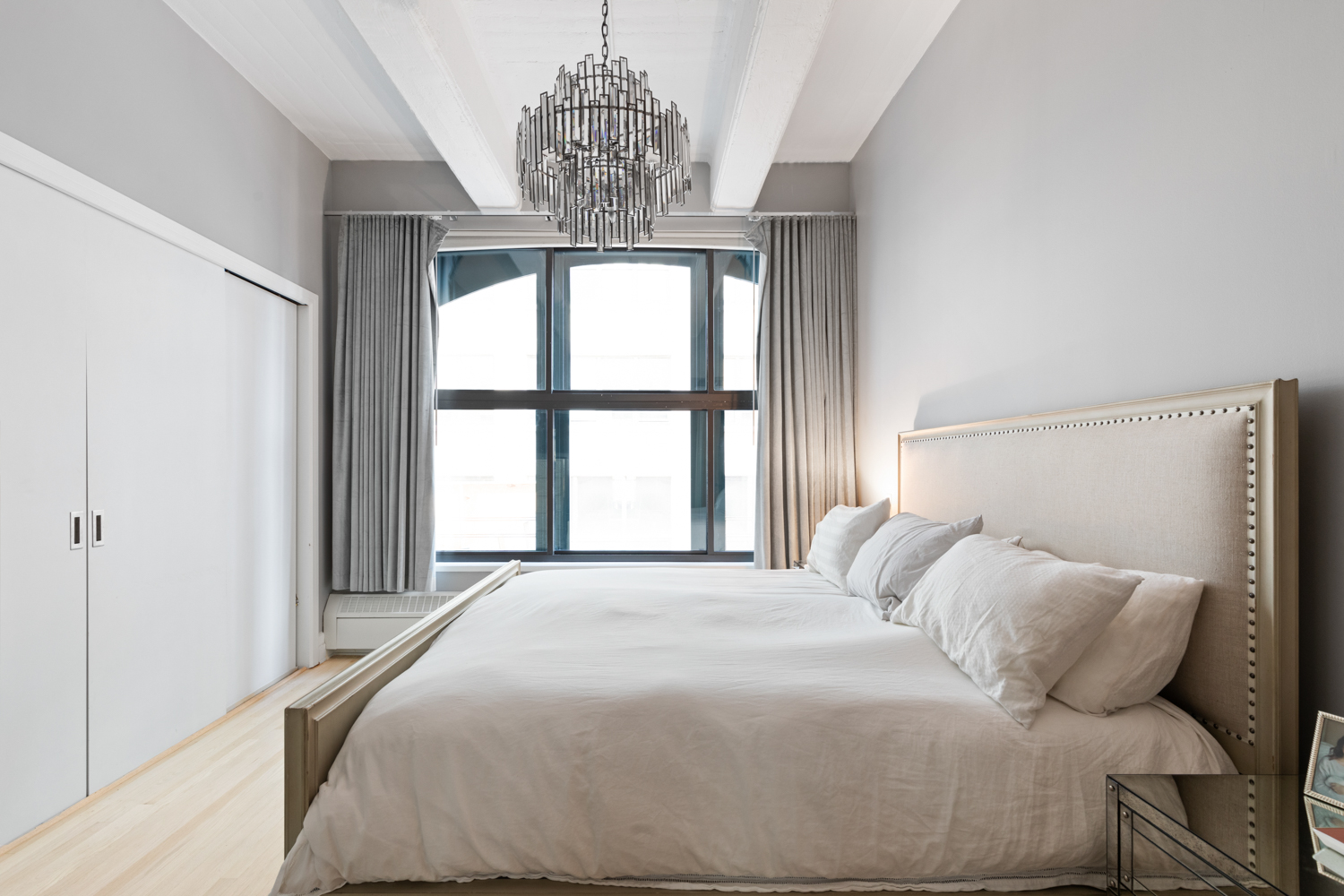 30 Main Street, Unit 3C Brooklyn, NY 11201 - Photo 8 of 18 a bedroom with a large bed and a chandelier
